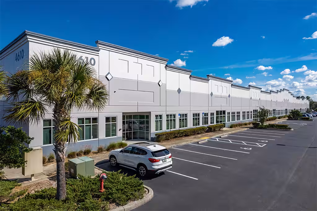 Compark 75 building with palm trees and its parking lot.